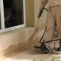 General pest control technician spraying exterior perimeter around a home in Minneapolis, MN